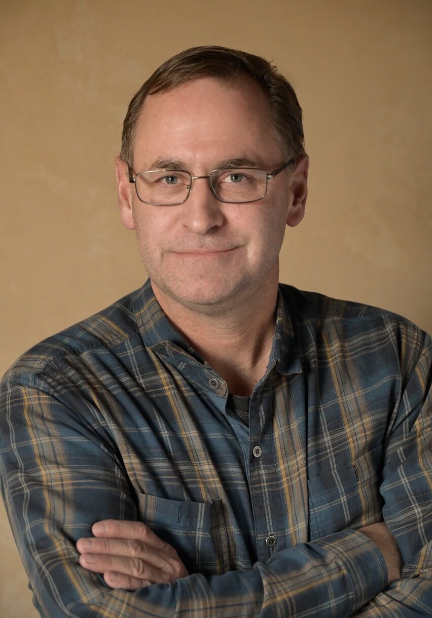 Gabe Abernathy, founder of Star Electric of Montana - portrait against a warm beige backdrop